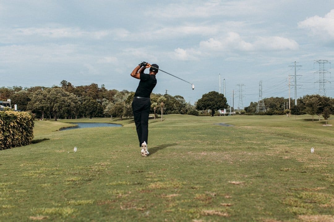 Un golfeur se concentrant sur sa technique de swing sur le parcours de golf.