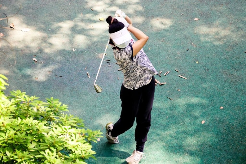Golfeur en train de s'échauffer avant un parcours de golf, améliorant ses performances.