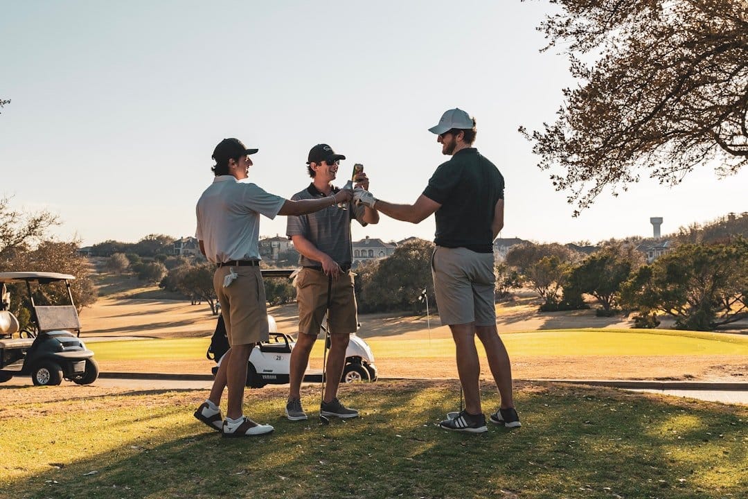Cinq golfeurs respectant l'étiquette sur le parcours avec une vue panoramique.